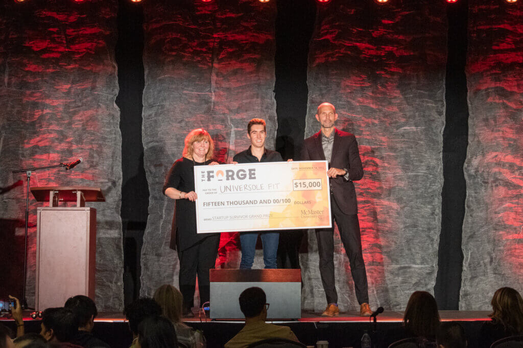 Universole Fit co-founder Joshua McGillivray receives the Forge Startup Survivor grand prize of $15,000 from Provost Susan Tighe and Dean of Students Sean Van Koughnett.