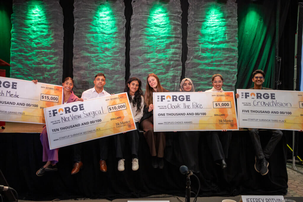 Startup Survivor 2023 winners posing on stage with their cheques.